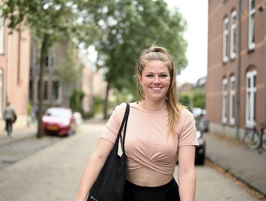 Smiling and happy young Dutch woman walking in a traditional str
