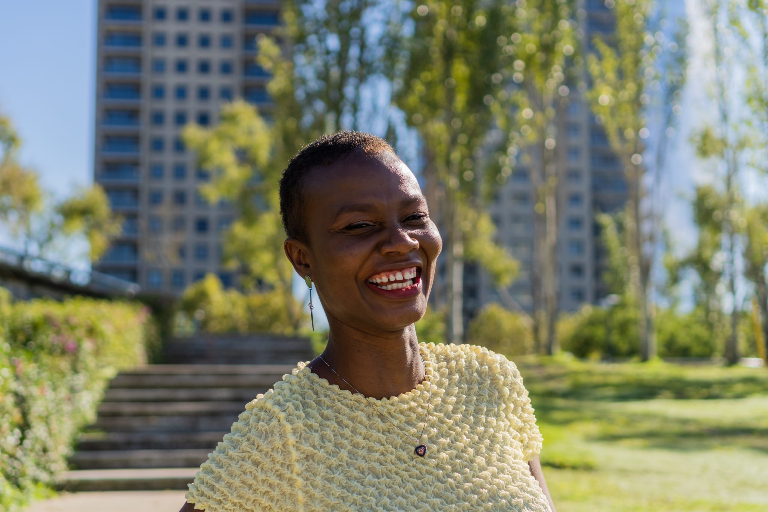 Portrait of a young Afro-American woman laughing looking at the camera standing in nature