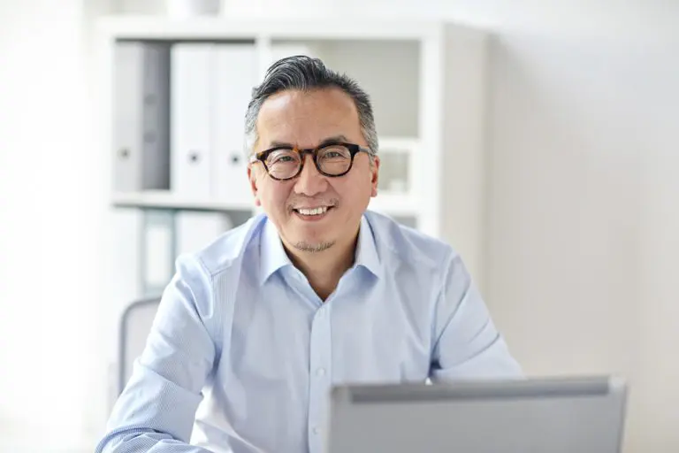 happy businessman in eyeglasses with laptop office