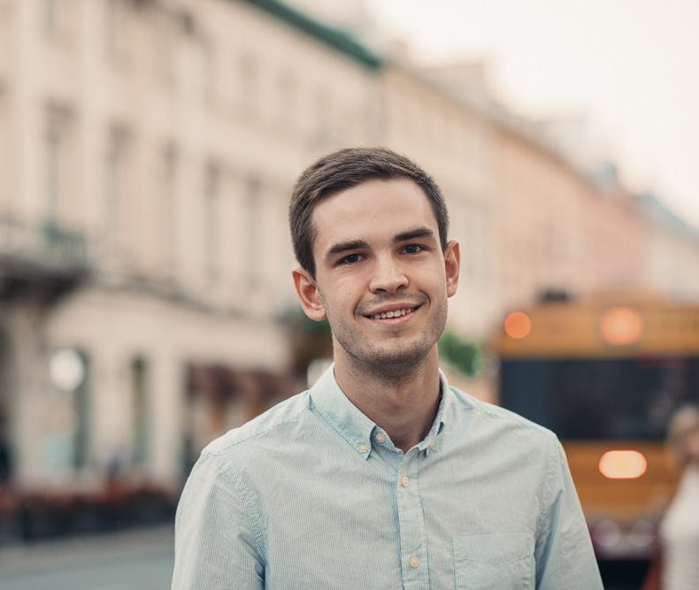 Smiling young man standing in the city