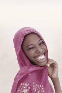 Joyful teenager wearing a pink veil for a celebration