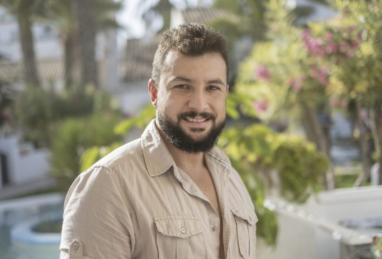 Forty years old man portrait in garden looking at camera and smi