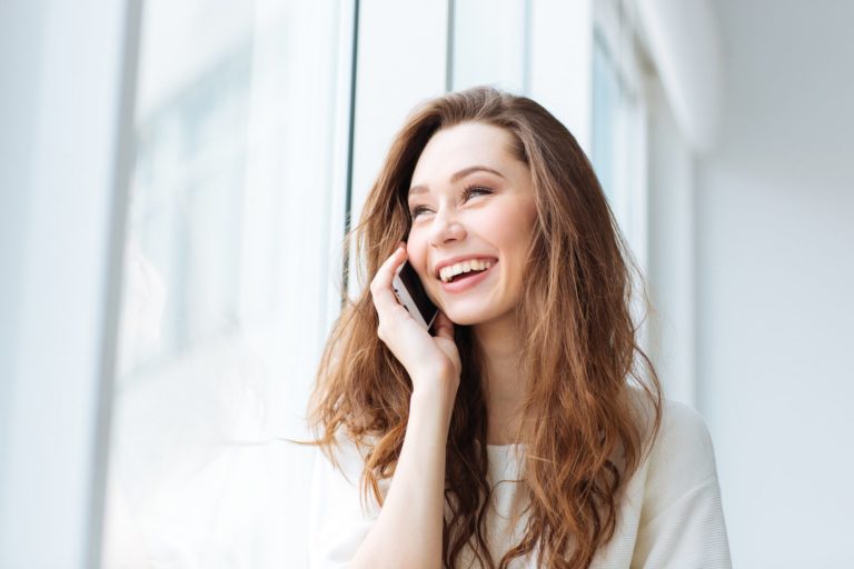 Woman talking on the phone and looking at window