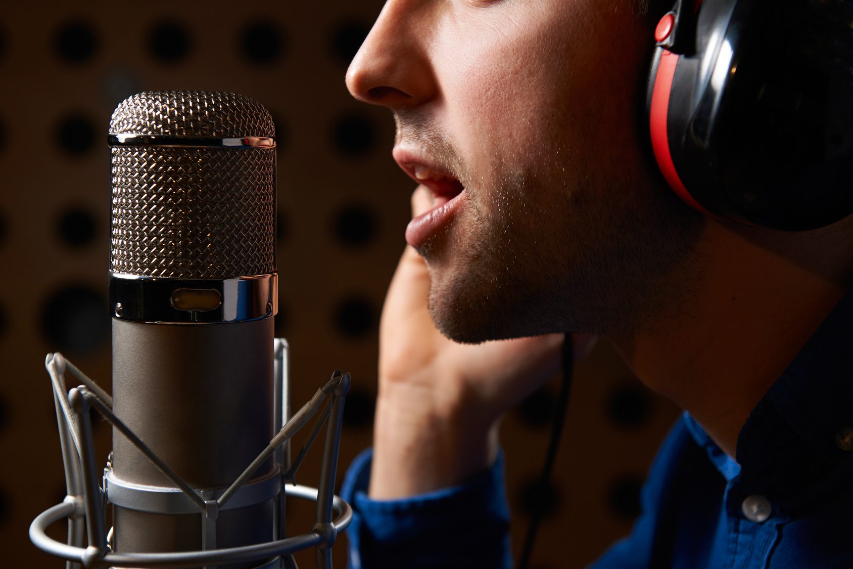 Male Vocalist Singing Into Microphone In Recording Studio