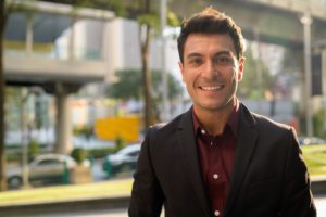 Face of happy young handsome Hispanic businessman smiling in the city